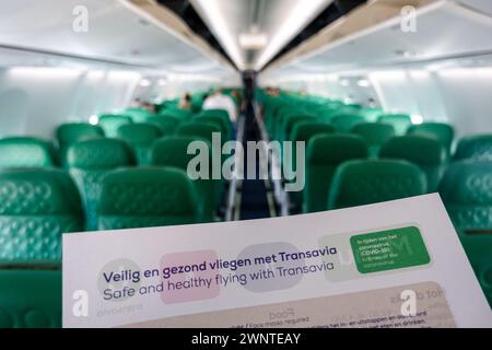 Sicherheitsblatt im Fokus in einer leeren Flugzeugkabine eines Transavia-Flugzeugs mit grünen Sitzen Stockfoto