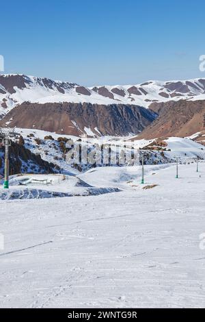 Seilbahnstange, Bau. Winterurlaub Aktivität, Lifestyle Sport und Erholung. Skifahrer und Snowboarder fahren mit dem Skilift hinauf, der zum Gipfel führt Stockfoto