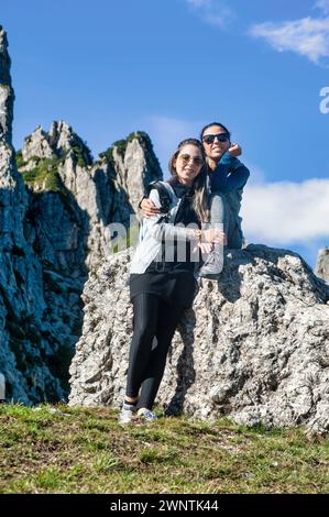 Zwei junge Freunde umarmen sich während einer Pause beim Wandern in den Bergen Stockfoto