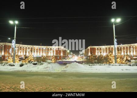 Petrosawodsk, Karelien, Russland, 01.13.2024: Gagarin-Platz, Blick auf die Leninallee, Weihnachtsbäume. Winterabend oder -Nacht, Schnee weht in der Nähe der Straße Stockfoto