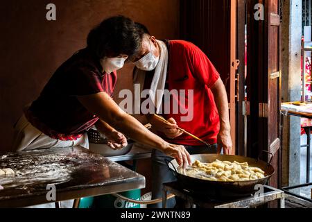 Jomtien, Thailand, 10. Februar 2024: Chakngeaw Chinese Village. Ein Paar macht Youtiao, einen langen goldbraunen, frittierten Streifen Weizenmehlteig. Stockfoto