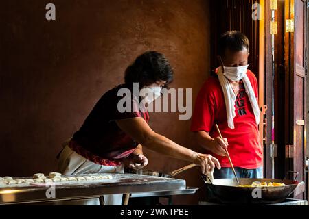 Jomtien, Thailand, 10. Februar 2024: Chakngeaw Chinese Village. Ein Paar macht Youtiao, einen langen goldbraunen, frittierten Streifen Weizenmehlteig. Stockfoto