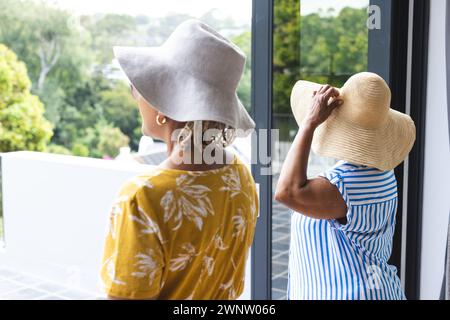 Ältere afroamerikanische Frau und ältere birassische Frau genießen im Urlaub eine Aussicht von einem Balkon Stockfoto