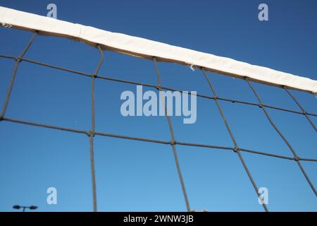 Volleyballsport, das Netz gegen die Nahaufnahme des blauen Himmels aufteilt. Outdoor-Sport Stockfoto