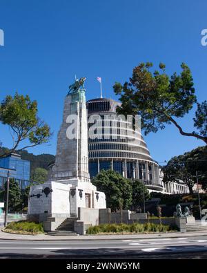 Das neuseeländische Parlamentsgebäude, auch bekannt als Bienenstock, und das Kriegsdenkmal, stehen vor einem klaren blauen Himmel im Zentrum von Wellington Stockfoto