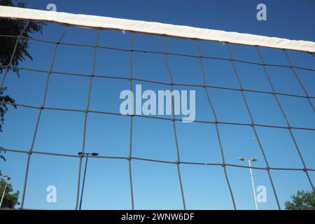 Volleyballsport, das Netz gegen die Nahaufnahme des blauen Himmels aufteilt. Outdoor-Sport Stockfoto