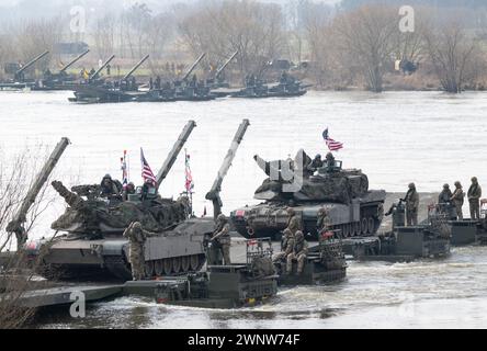 Korzeniewo, Polen. März 2024. Soldaten der US-Armee (Front) und Soldaten der Bundeswehr nehmen an einer gemeinsamen Militärübung auf der Weichsel mit Truppen aus mehreren NATO-Ländern Teil. Rund 20.000 Soldaten aus neun NATO-Ländern nehmen an der Übung Dragon 24 auf Polens längstem Fluss Teil. Die Überquerung der Weichsel ist ein Test der Zusammenarbeit zwischen den Streitkräften an Land, auf See, in der Luft und im Cyberspace. Quelle: Sebastian Kahnert/dpa/Alamy Live News Stockfoto