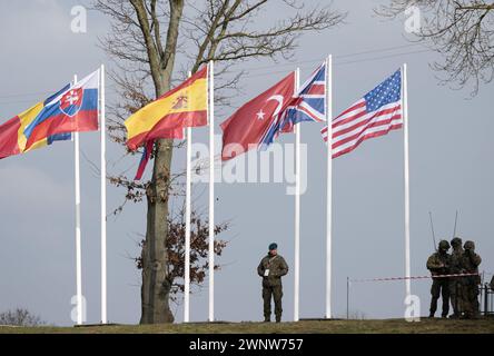 Korzeniewo, Polen. März 2024. Soldaten stehen unter zahlreichen Flaggen während einer gemeinsamen Militärübung mit Streitkräften aus mehreren NATO-Ländern auf der Weichsel. Rund 20.000 Soldaten aus neun NATO-Ländern nehmen an der Übung Dragon 24 auf Polens längstem Fluss Teil. Die Überquerung der Weichsel ist ein Test der Zusammenarbeit zwischen den Streitkräften an Land, auf See, in der Luft und im Cyberspace. Quelle: Sebastian Kahnert/dpa/Alamy Live News Stockfoto