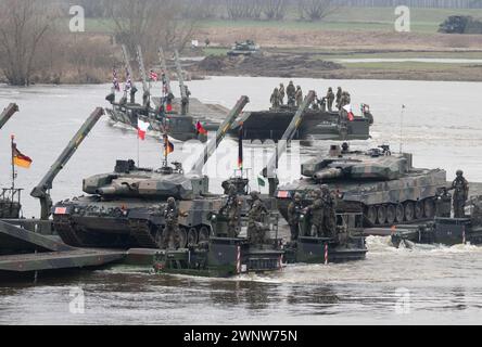 Korzeniewo, Polen. März 2024. Soldaten der Bundeswehr (Front) und britische Soldaten nehmen an einer gemeinsamen Militäraktion mit Streitkräften aus mehreren NATO-Ländern auf der Weichsel Teil. Rund 20.000 Soldaten aus neun NATO-Ländern nehmen an der Übung Dragon 24 auf Polens längstem Fluss Teil. Die Überquerung der Weichsel ist ein Test der Zusammenarbeit zwischen den Streitkräften an Land, auf See, in der Luft und im Cyberspace. Quelle: Sebastian Kahnert/dpa/Alamy Live News Stockfoto