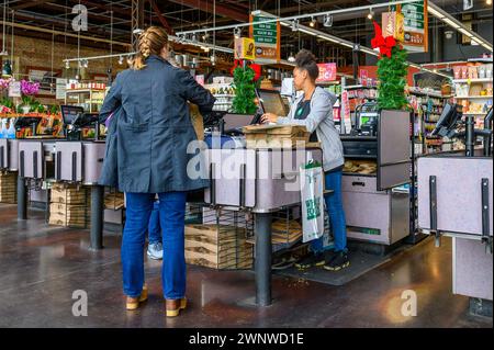 NEW ORLEANS, LA, USA – 5. DEZEMBER 2023: Kasse mit Kassierer und Kunden im Supermarkt „Uptown Whole Foods“ Stockfoto