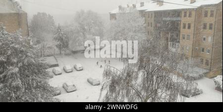 Sremska Mitrovica, Serbien, 12. Dezember 2021. Invasion eines Schneestyklons. Frischer weißer Schnee bedeckte den Innenhof und geparkte Autos. Wintertag Stockfoto