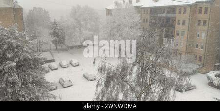 Sremska Mitrovica, Serbien, 12. Dezember 2021. Invasion eines Schneestyklons. Frischer weißer Schnee bedeckte den Innenhof und geparkte Autos. Wintertag Stockfoto