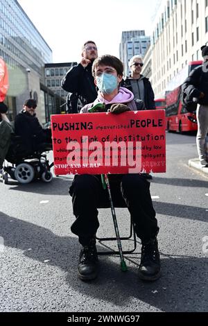 Caxton House, London, Großbritannien. März 2024. Behinderte Menschen gegen Kürzungen protestierten gegen das Ministerium für Arbeit und Pensionen (DWP) gegen sogenannte Wohlfahrtsreformen, die schutzbedürftige Menschen angreifen. Im Laufe der Jahre gab es mehr als 100.000 Todesfälle aufgrund von Kürzungen der Sozialleistungen, fehlendem Zugang zur Gesundheitsversorgung, verweigerten Sozialleistungen und Energiekrisen. Behinderte Menschen mit Rollstuhl blockieren die Straße vor der Westminster Abbey in London. Quelle: Siehe Li/Picture Capital/Alamy Live News Stockfoto