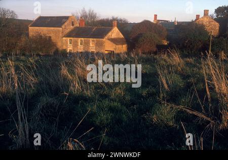 Lower Spargrove Farm und verbrannte Cottages. Spargrove Manor House, Batcombe, Somerset. 1988 1980er Jahre Großbritannien. Das heruntergekommene, mit Wassergraben versehene Manor House wurde von den zurückgezogen lebenden Schwestern der Familie Parfitt besetzt, die in Armut lebten, während sie noch versuchten, ihre Farm zu erhalten. Das Herrenhaus war seit über 200 Jahren in ihrer Familie. HOMER SYKES Stockfoto