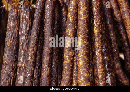 Serbische traditionell hergestellte und rauchgetrocknete Würstchen auf einem Bauernmarkt im Dorf Kacarevo, jährliches Festival mit Gastro-Speck und Trockenfleischprodukten Stockfoto