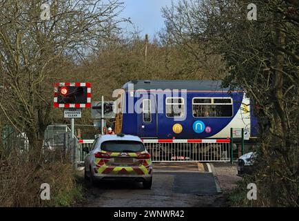 Ein nördlicher Zug nach Southport überquert den Bahnübergang in Chapel Lane, Parbold, Lancashire, wo neue automatische Barrieren installiert wurden. Stockfoto