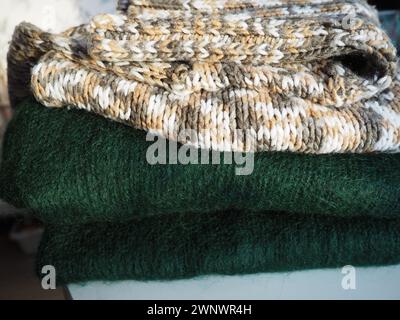 Strickkleidung, lässig gefaltet. Pullover aus Polyester und grüner Wolle. Warme Winterkleidung. Gestrickter Kaugummi Stockfoto
