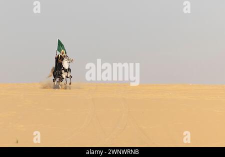 Mann in traditioneller Kleidung mit seinem Pferd in einer Wüste Stockfoto