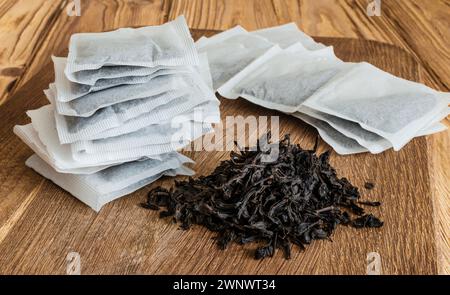 Teebeutel und ein Haufen losen Tees. Eine schnelle und bequeme Art, Tee zuzubereiten. Stockfoto