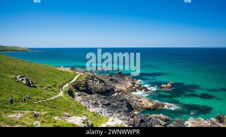 Blick auf den Küstenpfad, rund um die Landzunge in St. Ives, Cornwall, England. Es ist ein Sommertag und das Meer hat eine klare Blau- und Aquafarbe. Stockfoto