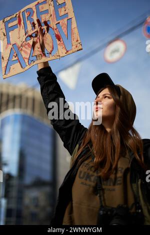 Die junge ukrainische Frau hält das Banner „Freies Asow“ auf einer öffentlichen Demonstration, die den im russischen Gefängnis festgehaltenen Asow-Brigade-Kämpfern gewidmet ist. Kiew - 3. März 2024 Stockfoto