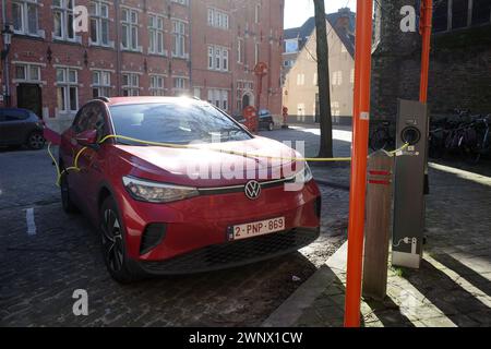 Brügge, Belgien - 27. Februar 2024 das Elektroauto Red Volkwagen wird geladen. Es ist ein sonniger Tag im Winter Stockfoto