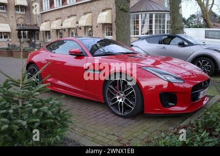 Sluis, Niederlande - 27. Februar 2024 Ein rotes Jaguar F-Type Parkett vor einem alten Kloster, das in ein Hotel umgewandelt wurde Stockfoto