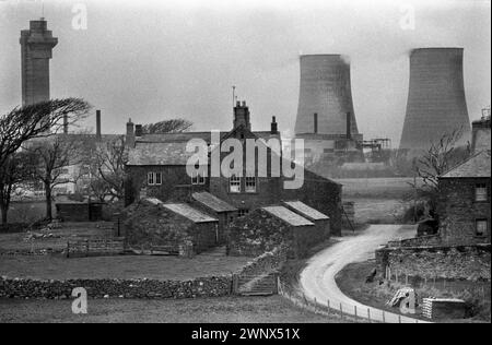 Calder Hall Nuclear Power Station Kühltürme Verarbeitungsanlage, British Nuclear Fuels. Jetzt bekannt als Sellafield. Die verlassene Calder Hall Farm und die Gebäude. Windscale, Cumbria, England 1983. HOMER SYKES AUS DEN 1980ER JAHREN Stockfoto