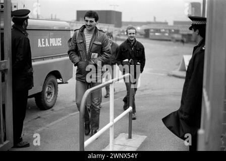 Männer verlassen ihre Arbeit am Ende einer Schicht am Haupttor der Fabrik. Die Polizei überwacht Fabrikarbeiter, die nach Hause gehen. Calder Hall, Nuclear Industry UK. Windscale und Calder Nuclear Processing Plant, British Nuclear Fuels. Windscale, Cumbria, England 1983. HOMER SYKES AUS DEN 1980ER JAHREN Stockfoto