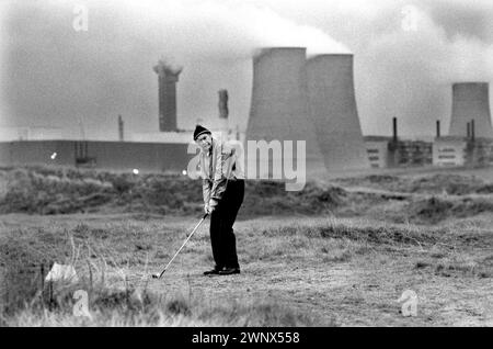 Kernkraftwerk Großbritannien. Windscale und Calder Nuclear Processing Plant. British Nuclear Fuels. Die Windscale Pfähle (einer auf diesem Foto) waren zwei luftgekühlte Graphitreaktoren auf dem Windscale-Kernkraftwerk in Cumberland (heute bekannt als Sellafield-Standort, Cumbria), Ein einheimischer Mann, der auf dem sogenannten toxischen Golfplatz spielte. Windscale, Cumbria, England 1983. HOMER SYKES AUS DEN 1980ER JAHREN Stockfoto