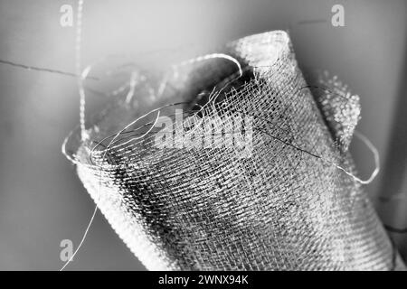 Metallgitter. Gerolltes Netz in Grau. Robustes Stahl- oder Aluminiumgitter mit ausgefransten Kanten. Stockfoto