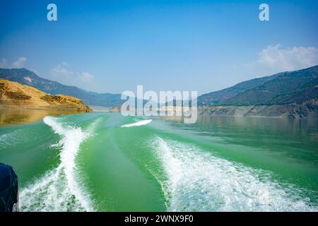 Tehri-See, Wasseroberfläche hinter einem Schnellboot im Tehri-See. Fahren Sie auf der Wasseroberfläche hinter dem Schnellboot. Rückansicht der Wellen hinter dem Spee Stockfoto