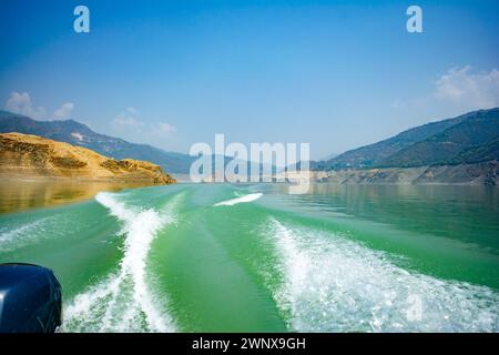 Tehri-See, Wasseroberfläche hinter einem Schnellboot im Tehri-See. Fahren Sie auf der Wasseroberfläche hinter dem Schnellboot. Rückansicht der Wellen hinter dem Spee Stockfoto