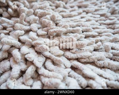 Nahaufnahme eines langen Haufens auf dem Teppich in Beige oder Grau. Rutschfeste Badvorleger oder Toilette. Langer Teppich. Zecken in Teppichen Stockfoto