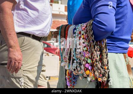 Acapulco, Mexiko - 17. Januar 2024: Straßenhändler mit Ketten um den Arm, die mit einem Touristen sprechen. Stockfoto