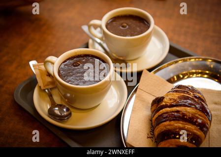 Einige Besucher trinken Schokolade im Geschäft Xocolates Pirineus in Puigcerdà (Cerdanya, Girona, Katalonien, Spanien) Stockfoto