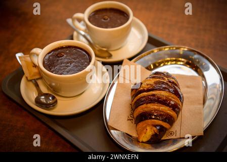 Einige Besucher trinken Schokolade im Geschäft Xocolates Pirineus in Puigcerdà (Cerdanya, Girona, Katalonien, Spanien) Stockfoto