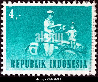 INDONESIEN - UM 1964: Eine in Indonesien gedruckte Briefmarke zeigt Postboten mit Fahrrad Stockfoto