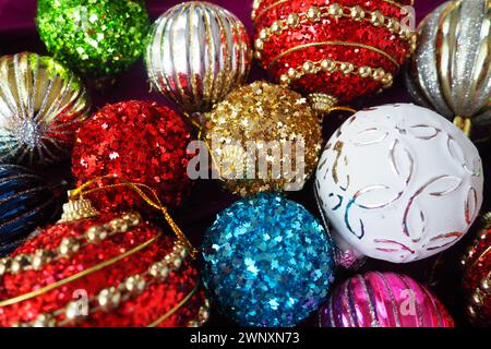 Bunte, glänzende Glaskugeln. Silvesterdekoration. Festliches Design. Rote, blaue, goldene, weiße, grün gestreifte Kugeln. Weihnachten und Neujahr Stockfoto