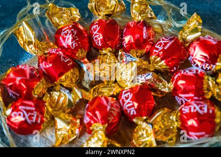 schokoladenbonbons, süß. Luxuriöse Schokoladen- und Mandeldragee in rotem Tablett Stockfoto