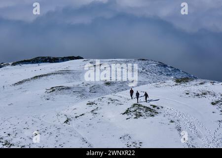 Wanderer klettern auf einem verschneiten Caer Caradoc, Church Stretton, Shropshire Stockfoto