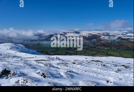 Schnee auf dem Long Mynd mit Nebel im Stretton Valley, mit Blick auf ganz Stretton von einem verschneiten Caer Caradoc, Church Stretton, Shropshire Stockfoto