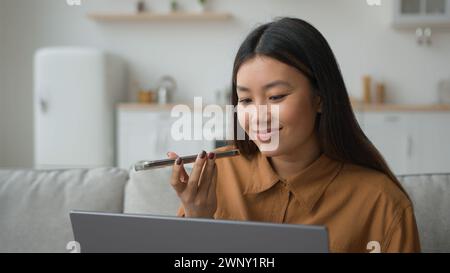 Asiatische Geschäftsfrau koreanisch indonesisch ethnische 30er Jahre Frau spricht Handy Aufzeichnung Sprachnachrichten auf Freisprecheinrichtung sprechen Smartphone auf Stockfoto