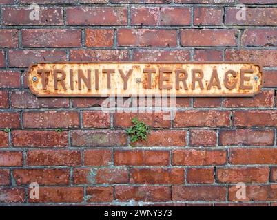 Straßenschild der Trinity Terrace auf einer alten Backsteinmauer in der Stadt Weymouth, Dorset, England, Großbritannien Stockfoto