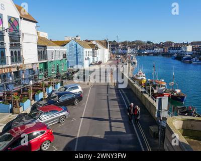 Custom House Quay in der Altstadt von Weymouth mit Weymouth Harbour auf der rechten Seite und mehreren Pubs auf der linken Seite in Dorset, England, Großbritannien. Stockfoto