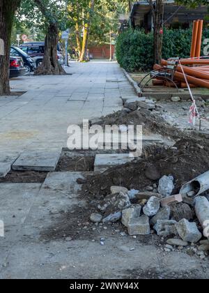 Reparatur der Kommunikation im Park. Rohre und Löcher im Rasen. Parkrenovierung. Stockfoto