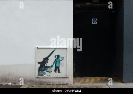 Ein Grafitti eines Mädchens und eine Rakete des weltberühmten Straßenkünstlers Banksy an einer Wand in Camden Town, London. Das Bildmaterial wird in Straßenkarten und Apps aufgeführt. Stockfoto