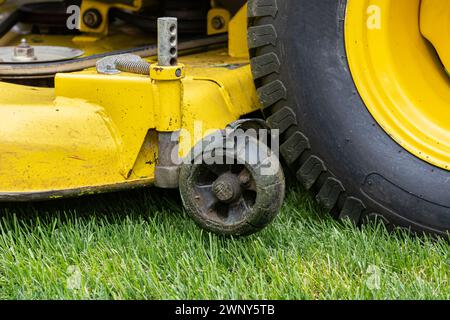 Stützrad des Rasenmähers gebrochen und beschädigt. Wartungs-, Reparatur- und Servicekonzept für Rasenanlagen. Stockfoto