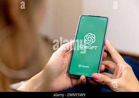 Frau, die ein Handy mit ChatGPT auf dem Bildschirm benutzt. Diese App ist ein Chatbot, der auf künstlicher Intelligenz basiert, die von OpenAI entwickelt wurde. Stockfoto