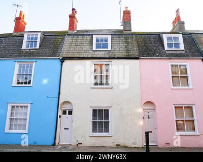 Eine Reihe farbenfroher Reihenhäuser in der Cove Street in der Altstadt von Weymouth an der Küste von Dorset in England. Stockfoto